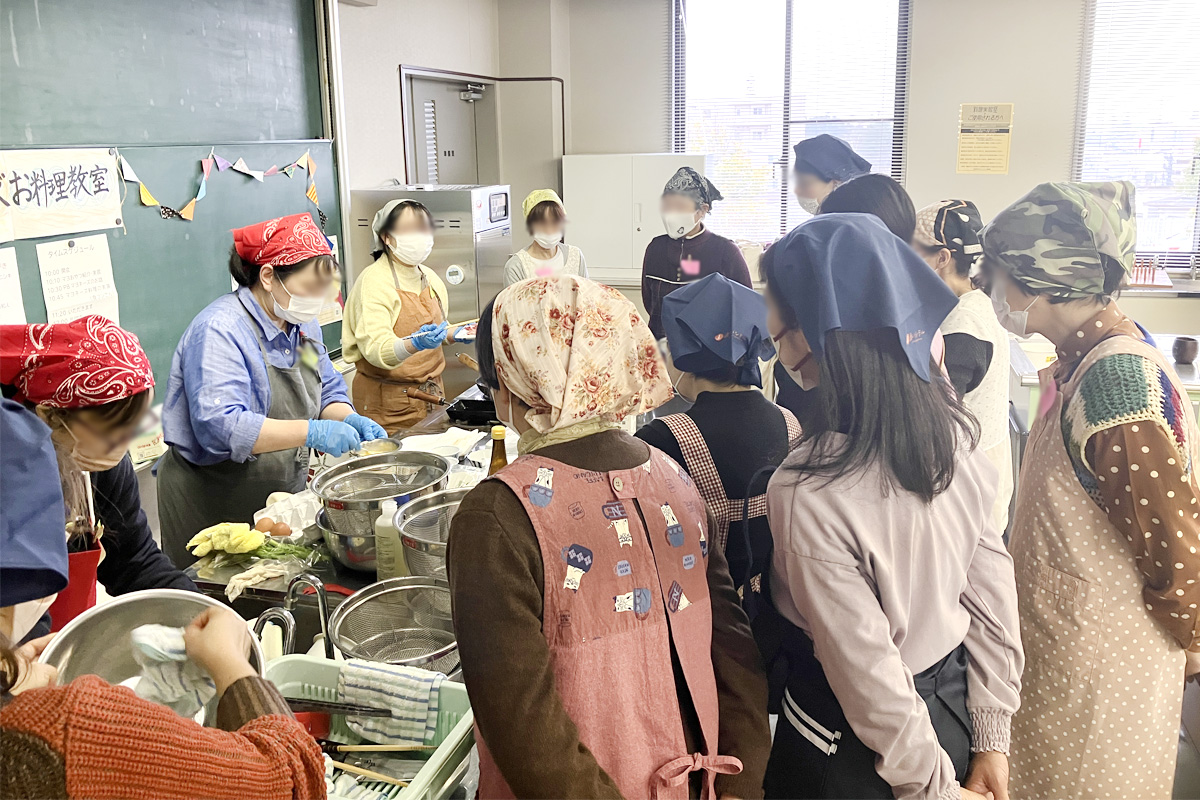 食コンさんから料理のコツを学んでいる参加者