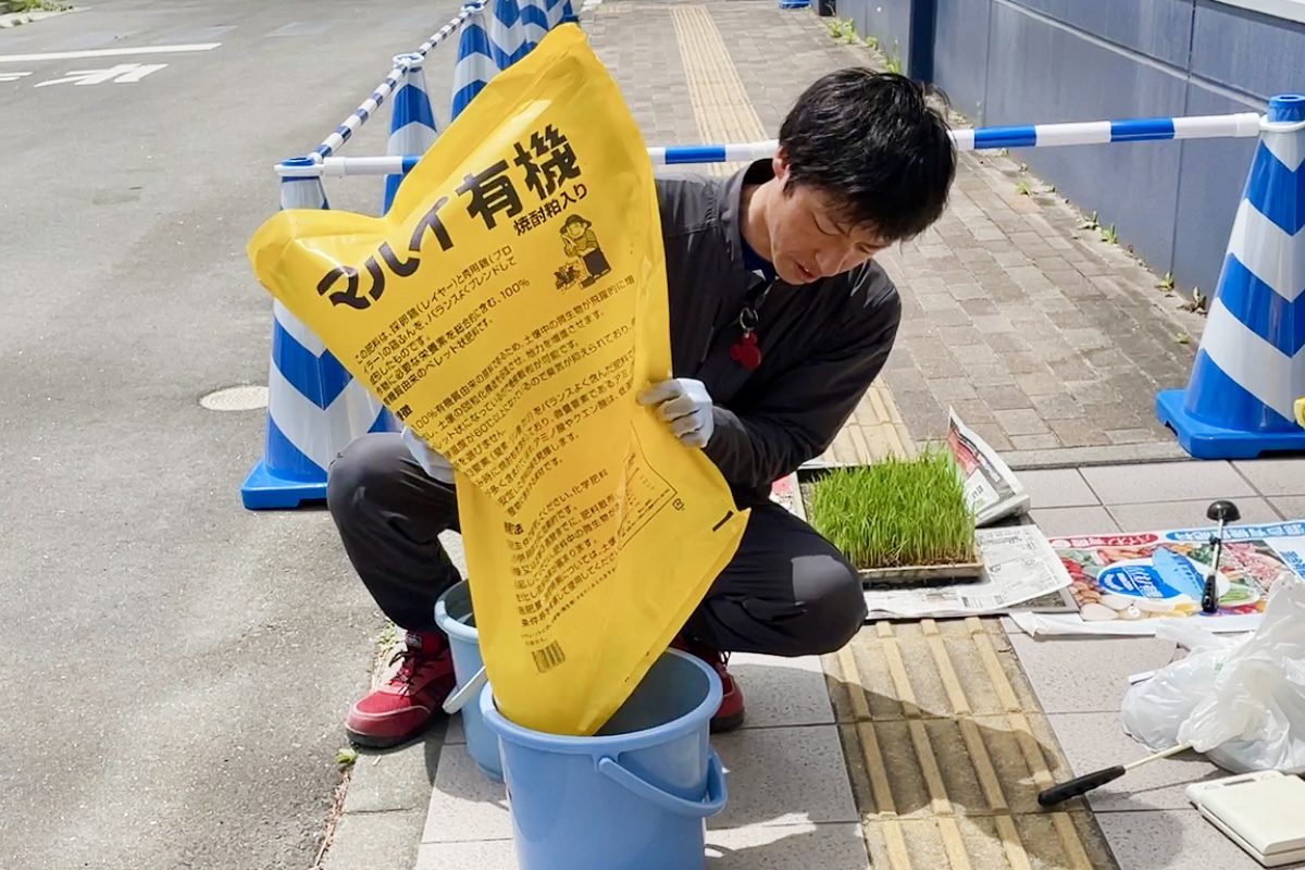 菅原達徳さんのデモンストレーション。土をザーッと入れまーす