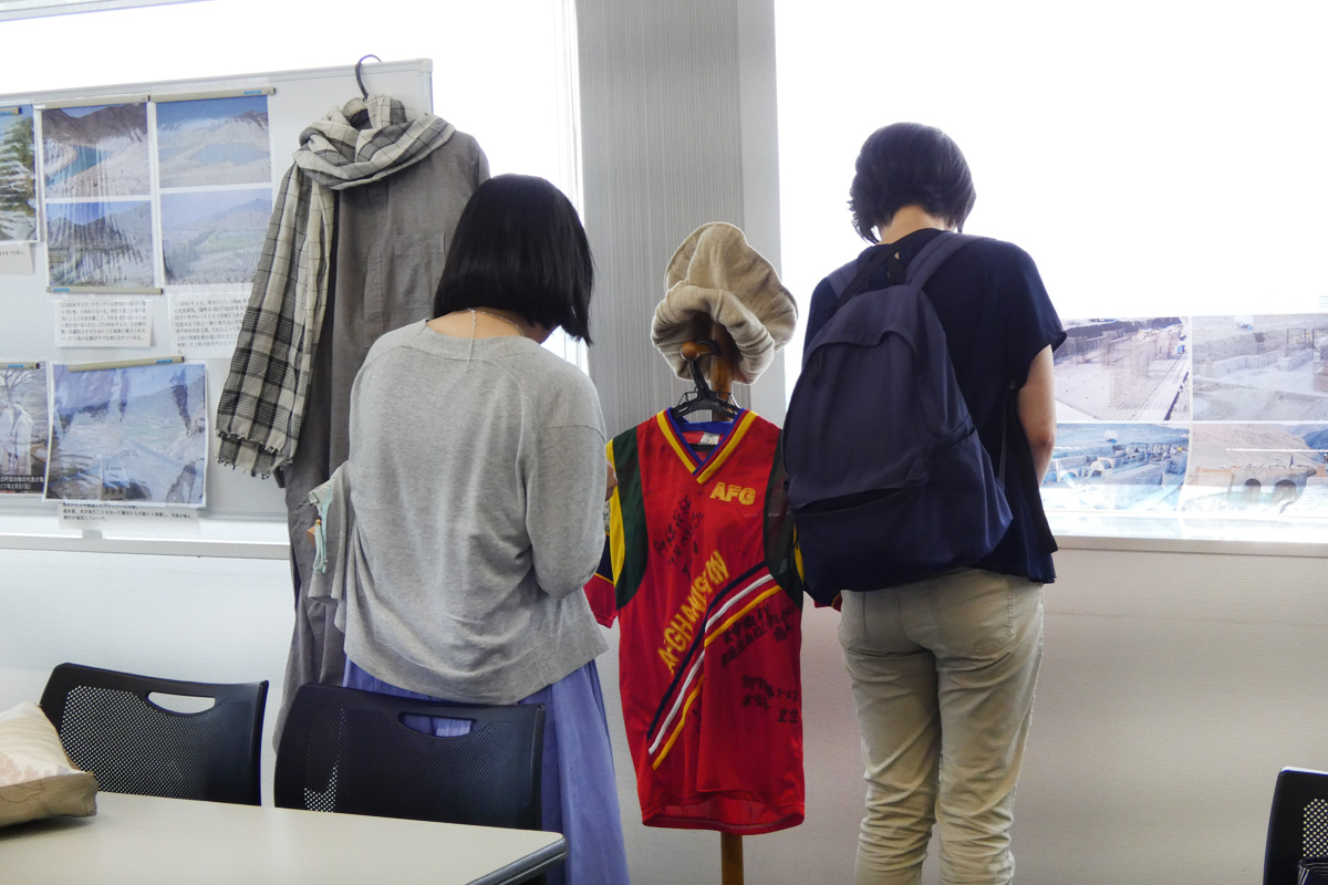 アフガニスタンの服や、中村医師直筆メッセージ入りの服に見入る参加者