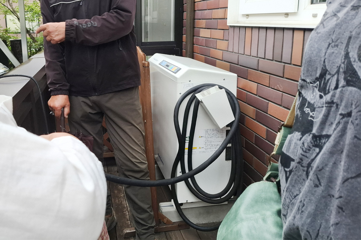 白い箱型の機械が車に蓄電された電気を家に戻すための機械（V2H）。