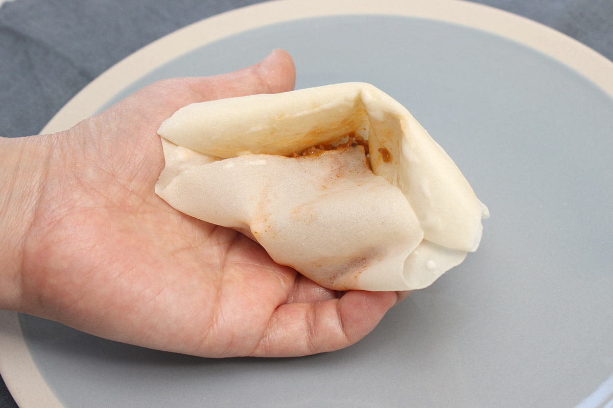 ８：具材の上に、下の三角の皮をかぶせる。小麦粉を水で溶いたのりをぬり、上側にくっつけて閉じる。