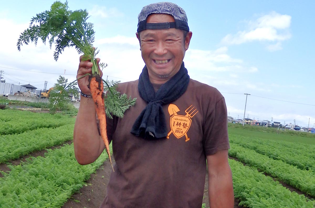 生育中の人参をもつ細谷さん