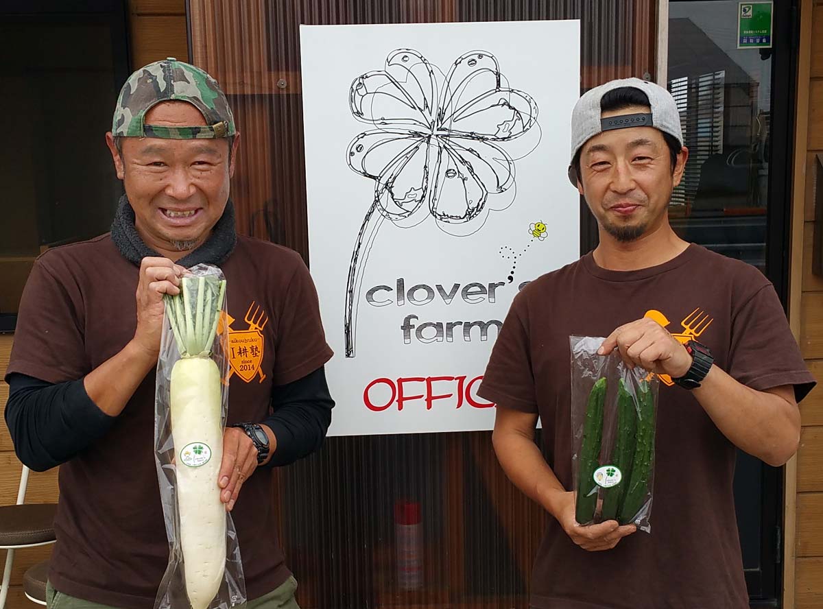 似顔絵入りのシールが張られた野菜を持つご本人